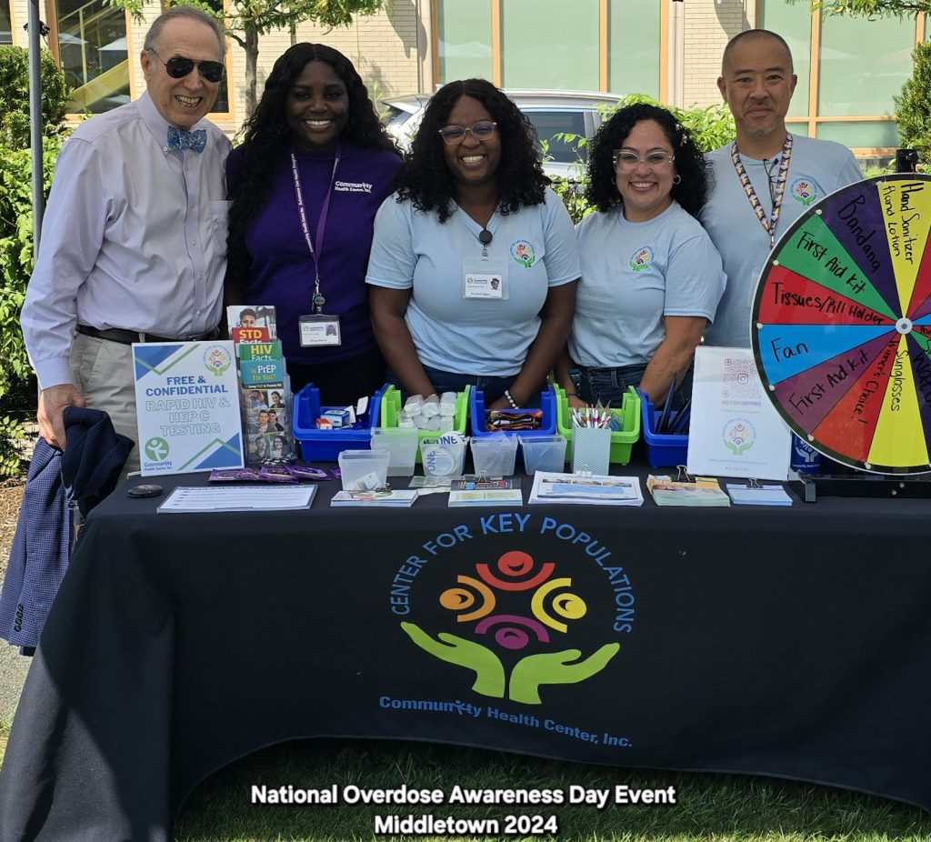 Center for Key Populations staff stand behind info table at National Overdose Awareness Day event, Middletown, CT